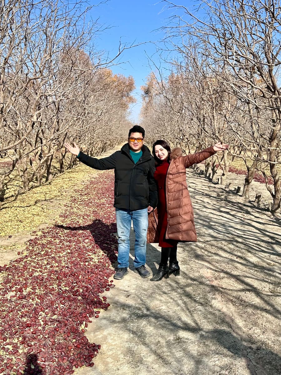 Đội ngũ Thắng Anh Fruits đứng giữa hàng cây táo đỏ trong vườn